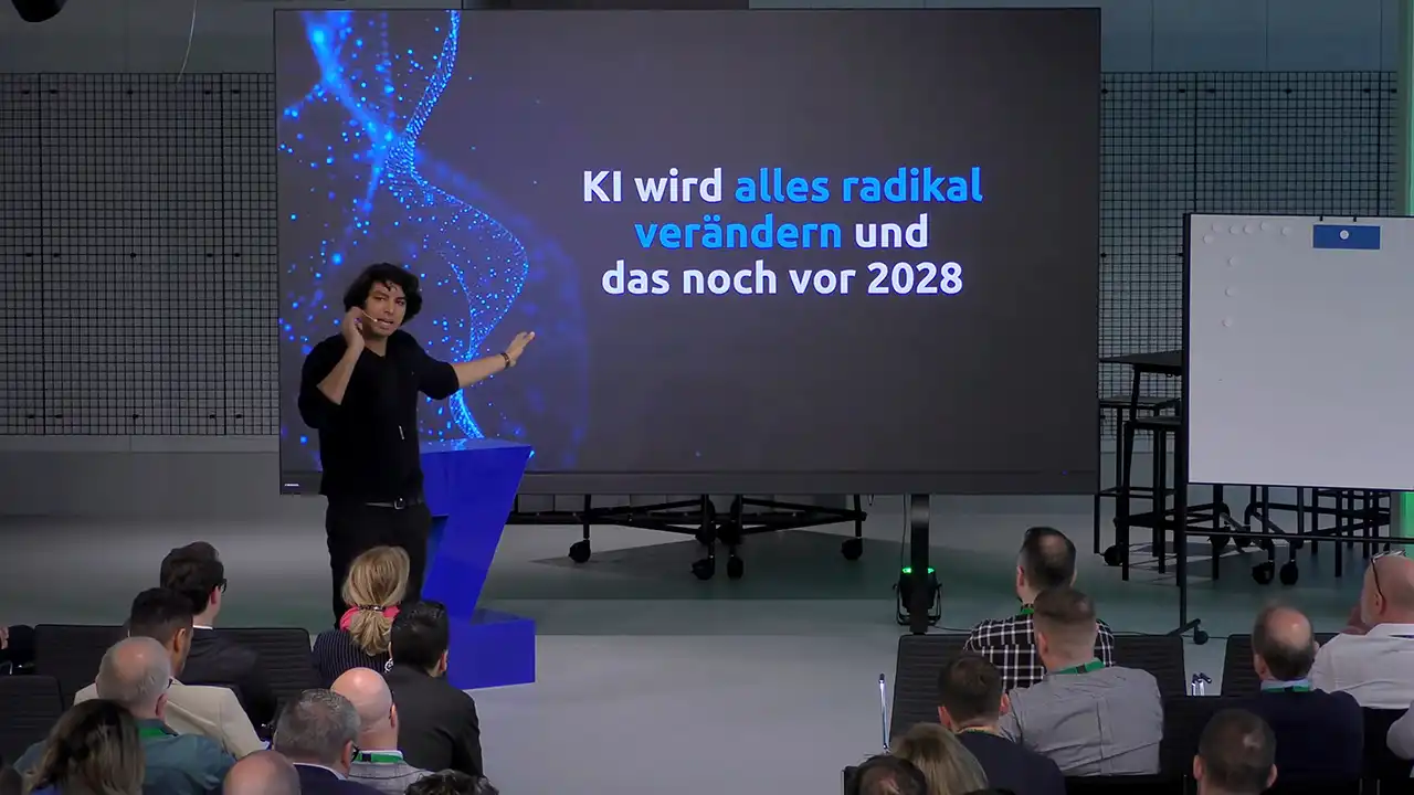 Eventfilm für Firmenveranstaltungen: So planst du einen Film, der das Event zeigt 3 Referent steht vor einer großen LED-Wand und spricht vor sitzendem Publikum bei einer Firmenveranstaltung