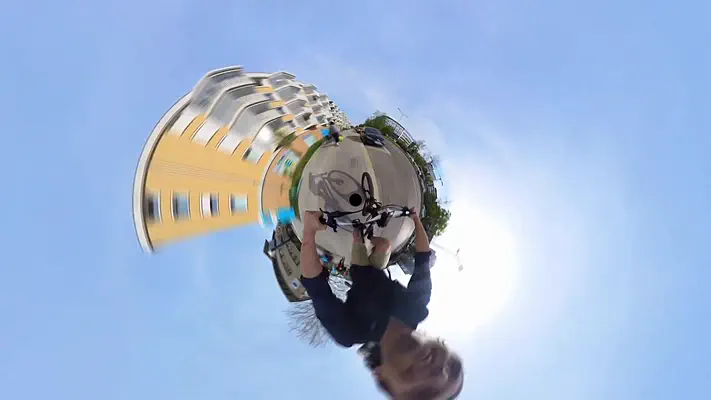 360 video 4 Spherical panorama from a 360-degree video with a yellow apartment building and green space.