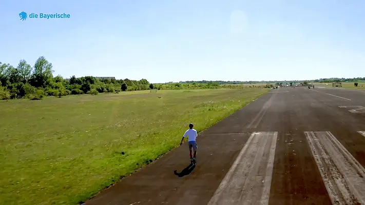 EB-Video Team 14 Aerial view of a person on a runway next to a meadow.
