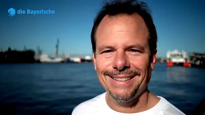 Image film production 14 Portrait of a smiling man in a white T-shirt in front of Hamburg harbour.