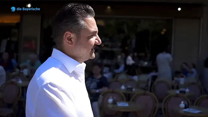 Recruiting Film 2 Man in a white shirt looking into a busy street café.