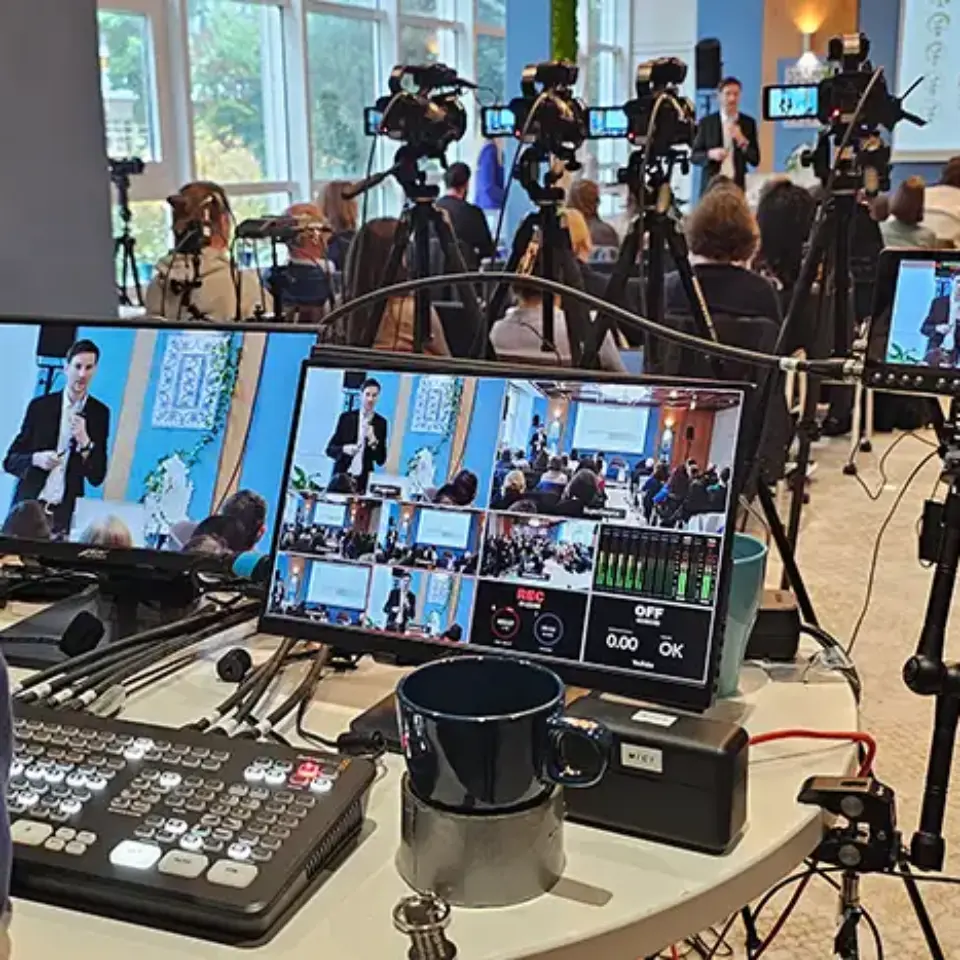 a group of cameras and a table with a laptop and a coffee cup