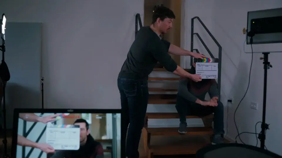 a man holding a box with another man sitting on stairs